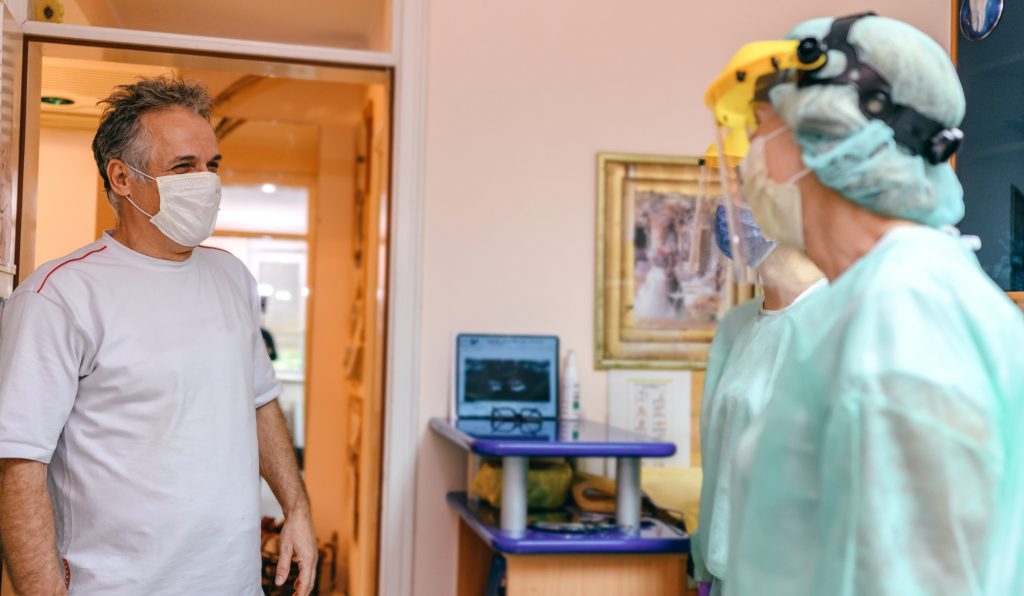 Patient in facemask and Dentist in full PPE