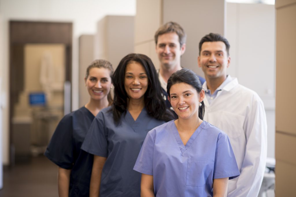 Group of smiling dental care professionals in office
