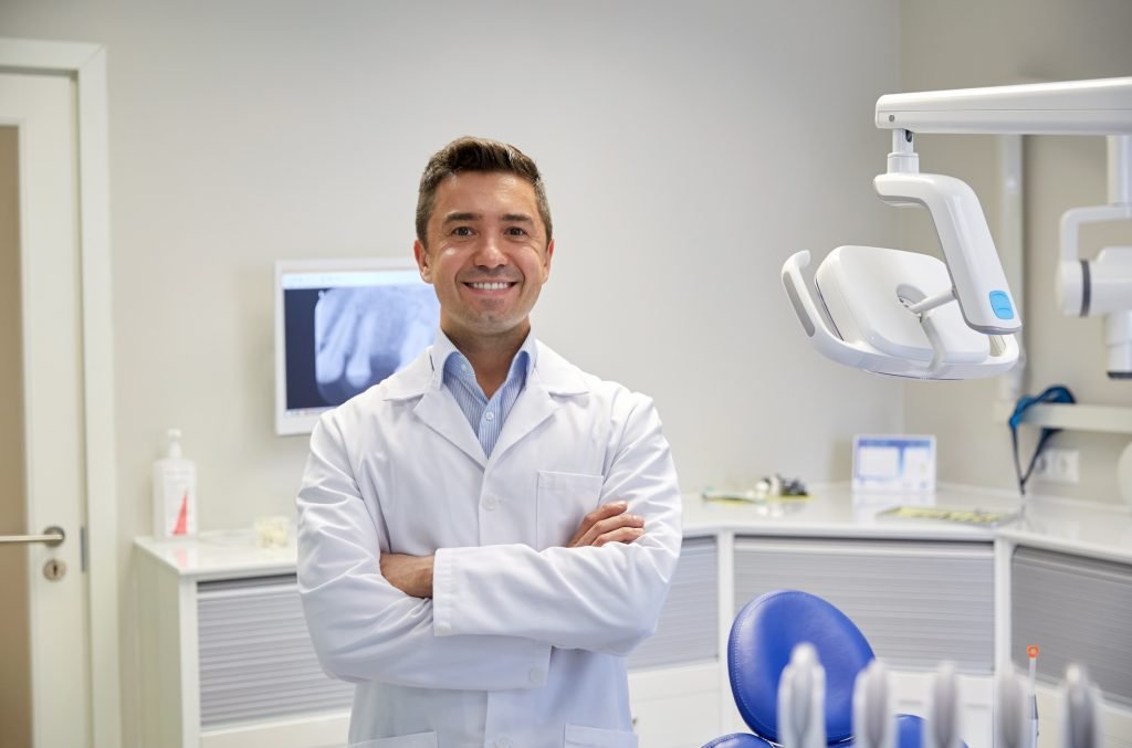 Smiling male dentist in office